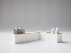 a white bench with two pillows on it