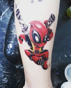 a deadpool tattoo on the leg of a person