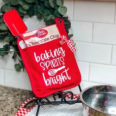 a red oven mitt sitting on top of a counter next to a metal pan