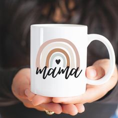 a woman holding a coffee mug with the word mama on it