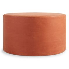 an orange round ottoman sitting on top of a white floor