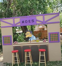 the simpsons bar with three stools in front of it and an image of homer