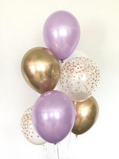 a bunch of balloons with gold and white confetti on them in a vase