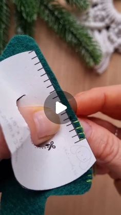 someone is holding a piece of paper and measuring it with a ruler in their hand