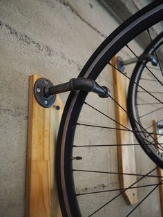 an image of a bicycle wheel on the wall with some hooks attached to it and another bike in the background