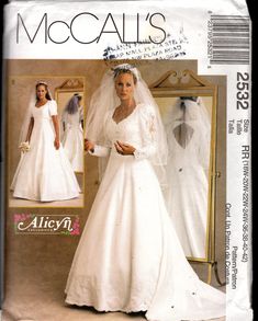 a woman wearing a wedding dress and veil in front of a mirror with the words mocallis's written on it