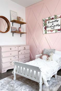 a bedroom with pink walls and white furniture