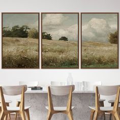 three paintings hanging on the wall above a dining room table