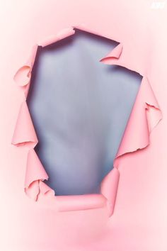 an abstract photo of pink paper with torn edges