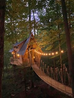 a small cabin in the woods with lights strung from it's roof and trees