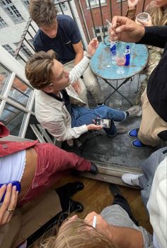 a group of people sitting around a table on top of a roof next to each other