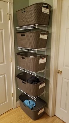 the closet is filled with plastic containers and laundry baskets, all organized in different sizes