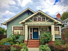 a blue house with white trim on the front door and steps leading up to it