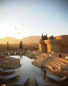 people are sitting at the edge of a pool in front of an outdoor seating area