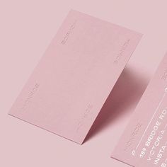 two pink business cards on a light pink background with the same color as the card itself