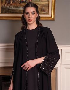 Step into sophistication with this luxurious black abaya, featuring intricately embellished sleeves adorned with sparkling crystals. The flowing silhouette is designed for comfort and elegance, perfect for both formal events and everyday wear. Crafted from premium fabric, this abaya offers a graceful drape and timeless appeal. Whether you're attending a special occasion or seeking a modest yet stylish outfit, this abaya is the ideal choice. Pair it with your favorite accessories for a complete l Luxury Long Sleeve Abaya For Eid, Elegant Long Sleeve Outerwear For Eid, Evening Embellished Fitted Abaya, Luxury Long Sleeve Evening Abaya, Embellished Fitted Evening Abaya, Fitted Long Sleeve Embellished Abaya, Traditional Black Long Sleeve Abaya, Evening Embellished Black Abaya, Evening Black Embellished Abaya