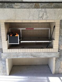 a brick fireplace with a toaster oven on it's side and fire in the back