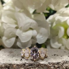 three stone ring with white flowers in the background