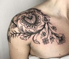 a man with a tattoo on his chest is wearing a black and white floral design