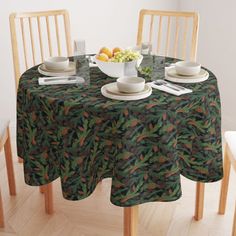 the table is set with plates and bowls of fruit on it, along with two chairs