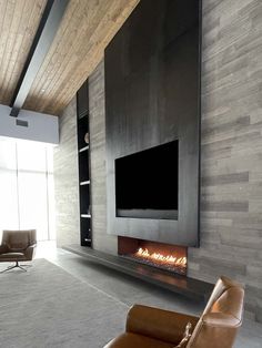 a modern living room with a fireplace and tv mounted on the wall in front of it