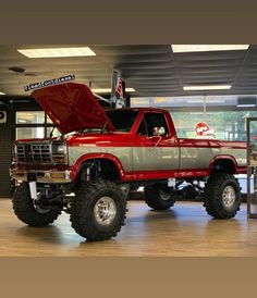 a large red truck parked inside of a garage