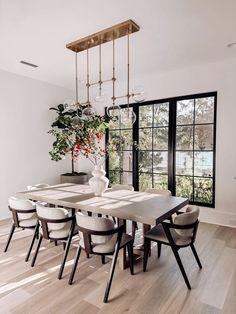 the dining room table is surrounded by white chairs