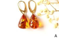 The earrings of Baltic amber in rich honey colour will not betray your expectations. It is one of the most popular colours of Baltic amber. Executed in the shape of a drop, they will perfectly match to any outfit. These lightweight, elegant, sophistically sparkling earrings with a spangle inside are an irresistible piece of jewellery that you will love wearing every day. It is a genuine, natural and unique piece of jewellery created by nature, so you will feel special on every occasion. Delight yourself or your loved one with a little miracle from nature.  EARRINGS A Earrings length with clasp: 3.8 cm. / 1.49 inch Weight: 4.1 g. / 0.14 oz Color: cognac, golden Natural Baltic amber 925 sterling silver gold plated EARRINGS B Earrings length with clasp: 4.1 cm. / 1.61 inch Weight: 3.9 g. / 0. Amber Teardrop Earrings As A Gift, Amber Teardrop Drop Earrings For Gift, Amber Teardrop Earrings Gift, Elegant Baltic Amber Teardrop Jewelry, Elegant Teardrop Baltic Amber Jewelry, Teardrop Baltic Amber Earrings In Amber, Baltic Amber Teardrop Earrings As Gift, Teardrop Baltic Amber Earrings, Amber Teardrop Baltic Amber Earrings