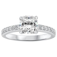 a cushion cut diamond ring with channeled shoulders