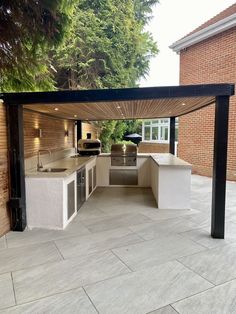 an outdoor kitchen and grill area in a backyard