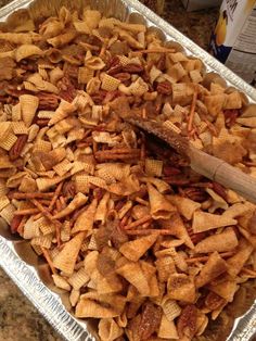 a pan filled with cheesy crackers and a wooden spatula on top