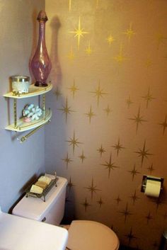 a bathroom with a toilet, sink and shelves on the wall