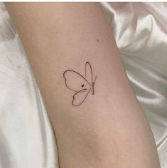 a small butterfly tattoo on the left inner arm and wrist, it looks like a single line drawing