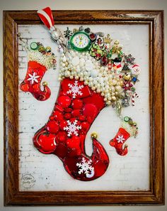 a red christmas stocking with white snowflakes and other holiday decorations hanging on a brick wall