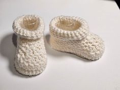 Looking for the perfect addition to your baby's wardrobe? Look no further than our collection of handmade crochet baby booties and crib shoes! Each pair of booties is carefully crafted by hand using high-quality yarn and designed with comfort and style in mind. Our baby booties come in a variety of colors and styles, from classic neutrals to fun and vibrant patterns. They are perfect for keeping little feet warm and snug, and the soft and stretchy material ensures a comfortable fit. Our crochet Knitted Booties With Round Toe For Gift, Knitted Round Toe Booties As Gift, White Booties As Winter Gift, White Winter Booties As A Gift, White Winter Booties As Gift, Cute Yarn Booties As A Gift, Cute Yarn Booties As Gift, Cute Knitted Round Toe Booties, Cute Hand Knitted Round Toe Booties