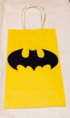 a batman bag sitting on top of a white tablecloth covered in yellow and black paper