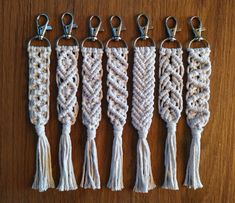 four different types of key chains with tassels attached to them on a wooden surface