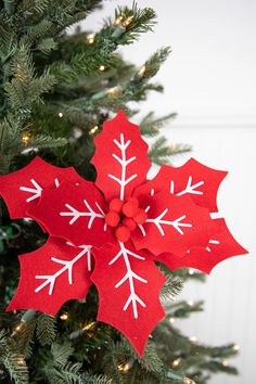 a christmas tree decorated with red paper and white snowflakes