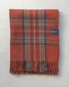 an orange plaid blanket on a wooden surface