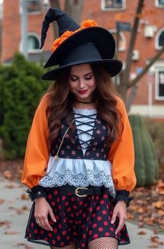 a woman wearing a black and orange outfit with a hat on top of her head