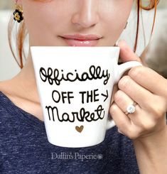 a woman is holding a coffee mug with the words off the market on it in front of her face