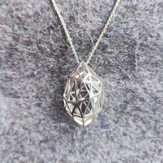 a diamond shaped pendant on a silver chain