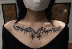 a woman wearing a mask with barbed wire on her chest