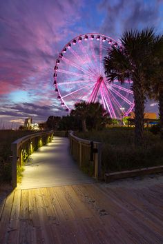 a ferris wheel sitting on top of a wooden boardwalk