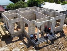 some people are standing in the middle of a house under construction with brick walls and pillars