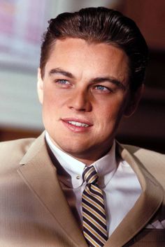 a close up of a person wearing a suit with a striped tie and jacket on