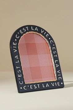 a small black and red plaque with the words ceest la vie on it