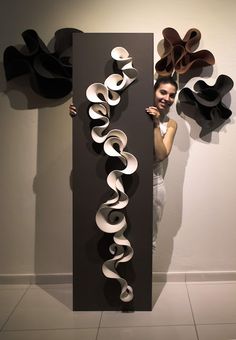 a woman standing next to a tall sculpture