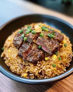 a black bowl filled with rice and meat