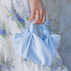 “Something Blue”Introducing the Baby Blue Silk Knot NLA Bag (medium size), a versatile and timeless accessory handmade in Los Angeles. Known for its unstructured elegance and understated look, this wristlet is a must-have addition to your collection. The baby blue satin creates a soft and serene aesthetic. An ideal “something blue” for brides on their wedding day or guests attending events, it’s buttery smooth, light and easy to wear on your wrist. The medium size (7 x 11’) fits all the essentia Blue Satin, Timeless Accessories, Medium Size, Medium Bags, Something Blue, Bridal Collection, Baby Blue, Bridal Shower, Wedding Day